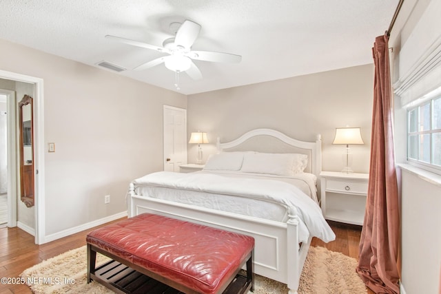 bedroom with ceiling fan, light hardwood / wood-style floors, and a textured ceiling