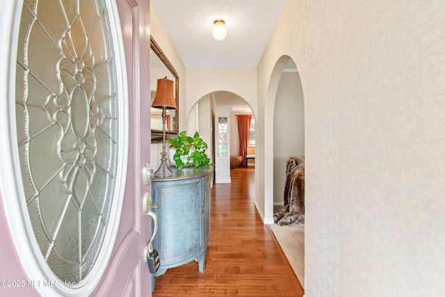 corridor with hardwood / wood-style flooring and a textured ceiling