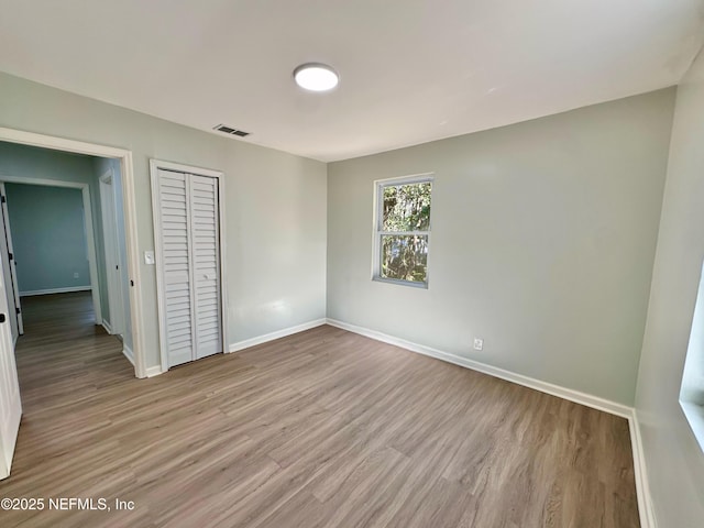 unfurnished bedroom featuring light hardwood / wood-style flooring and a closet