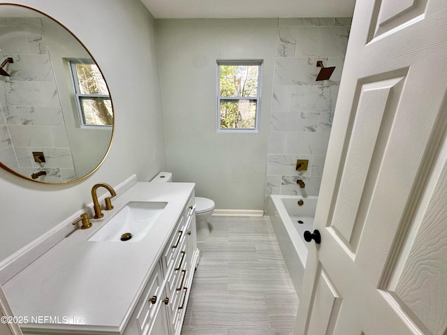 full bathroom with vanity, tiled shower / bath combo, and toilet