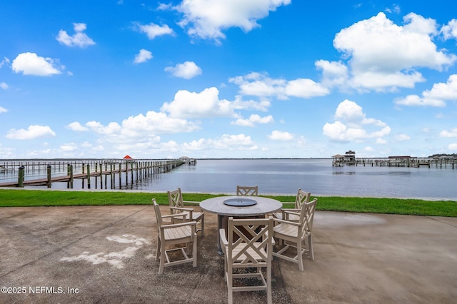 view of patio / terrace with a water view, a dock, and a fire pit