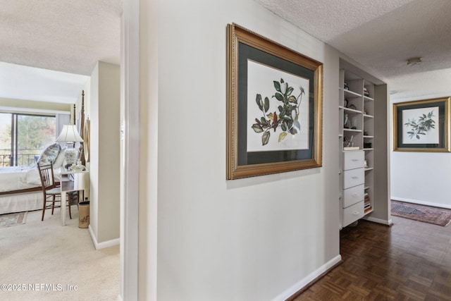 corridor featuring parquet floors and a textured ceiling