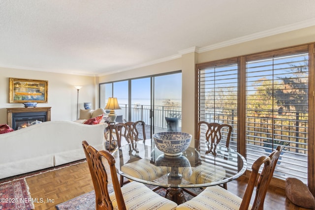 dining space featuring crown molding, a water view, parquet floors, and a textured ceiling