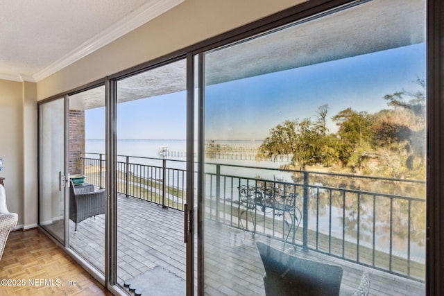 doorway to outside featuring ornamental molding, light parquet floors, and a water view