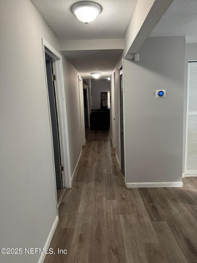 hall featuring dark hardwood / wood-style floors and a textured ceiling