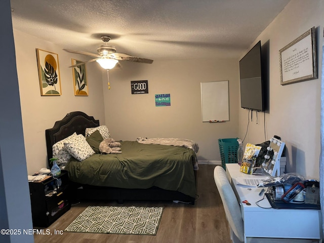 bedroom with ceiling fan, a textured ceiling, and dark hardwood / wood-style flooring