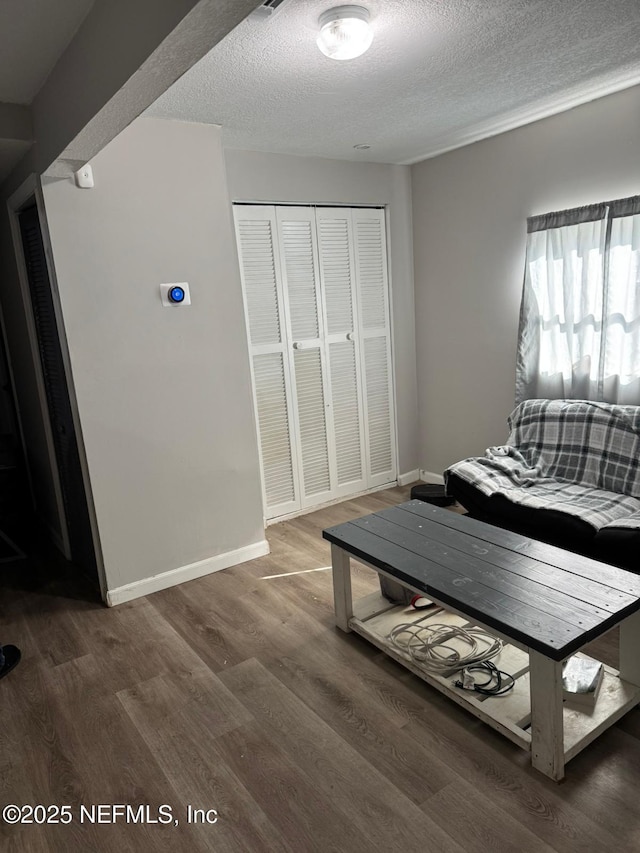 bedroom featuring hardwood / wood-style flooring, a textured ceiling, and a closet