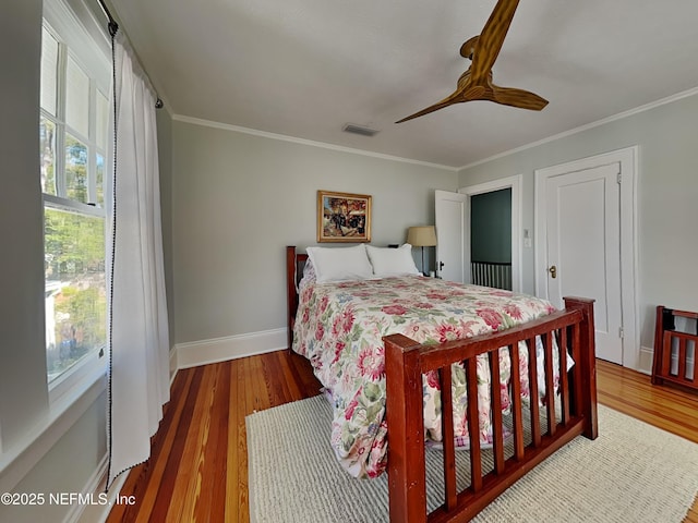 bedroom with hardwood / wood-style flooring, ceiling fan, and crown molding