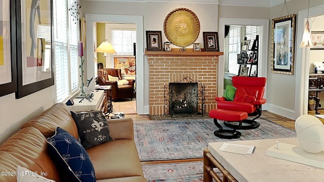 living room featuring crown molding, a brick fireplace, and hardwood / wood-style floors