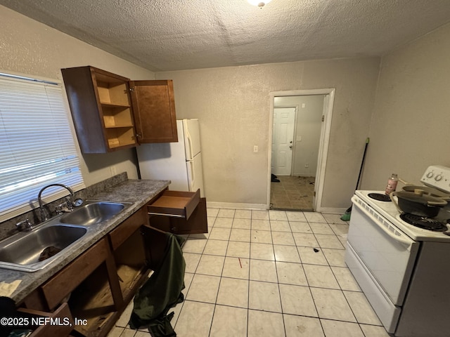 kitchen with sink, light tile patterned floors, a textured ceiling, and white appliances