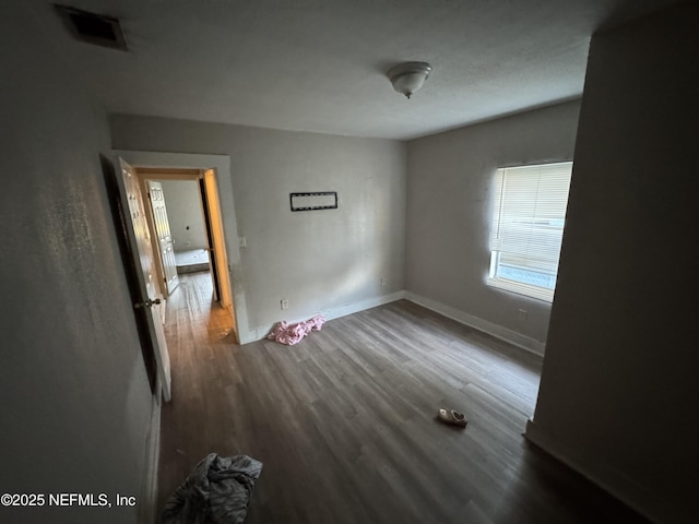 unfurnished room with dark wood-type flooring