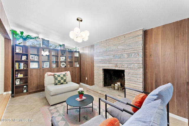 tiled living room featuring a fireplace, a textured ceiling, and wood walls