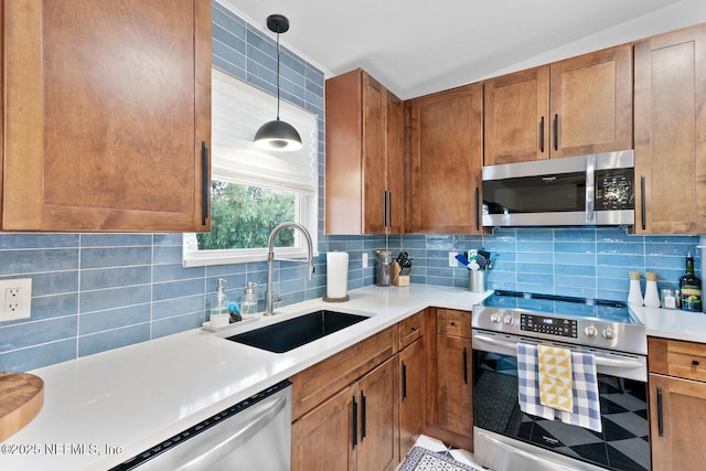 kitchen with tasteful backsplash, stainless steel appliances, decorative light fixtures, and sink