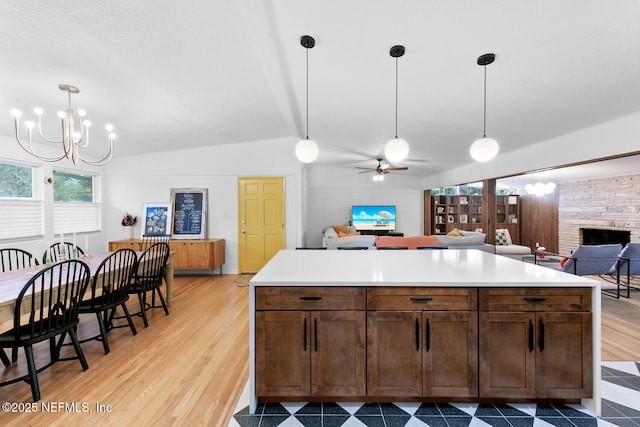 kitchen featuring lofted ceiling, hanging light fixtures, and light hardwood / wood-style flooring