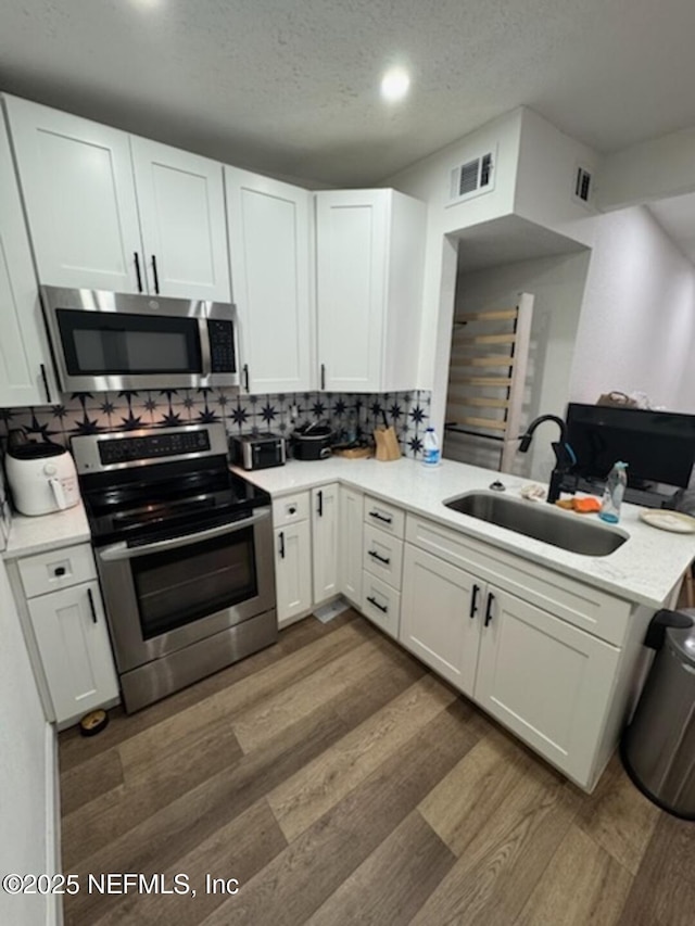 kitchen with white cabinetry, sink, dark wood-type flooring, and appliances with stainless steel finishes