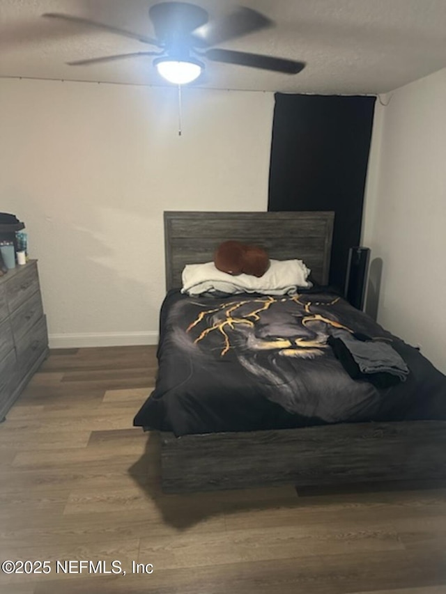 bedroom with hardwood / wood-style floors and ceiling fan