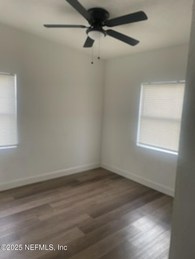 unfurnished room with ceiling fan and dark hardwood / wood-style flooring