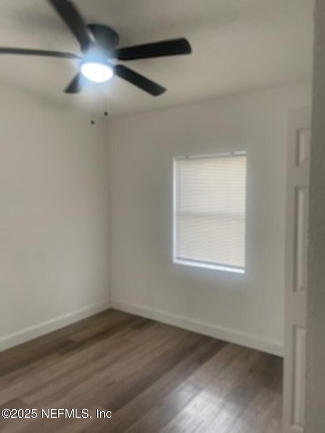 spare room featuring dark wood-type flooring and ceiling fan