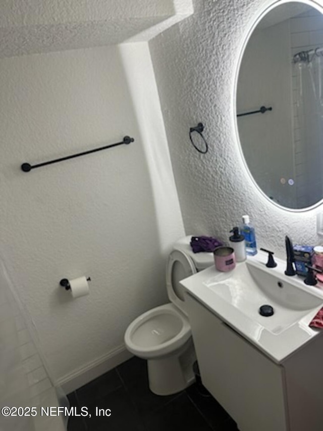 bathroom featuring walk in shower, vanity, toilet, and tile patterned flooring