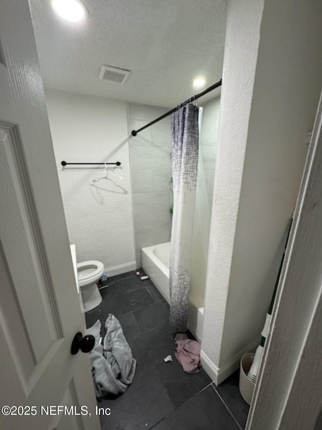 bathroom with toilet, a textured ceiling, and shower / bath combo