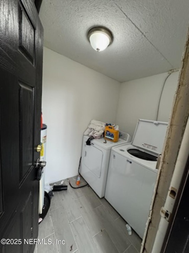 clothes washing area featuring washing machine and dryer and a textured ceiling