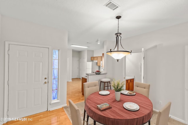 dining space with light hardwood / wood-style flooring