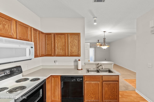 kitchen featuring electric stove, sink, pendant lighting, dishwasher, and a textured ceiling