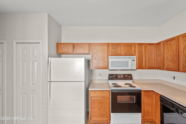 kitchen featuring white appliances and a textured ceiling