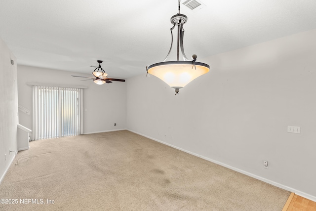 carpeted spare room with ceiling fan