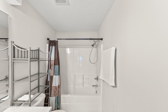 bathroom with shower / bath combo with shower curtain and a textured ceiling