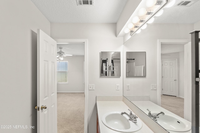 bathroom with vanity, ceiling fan, and a textured ceiling