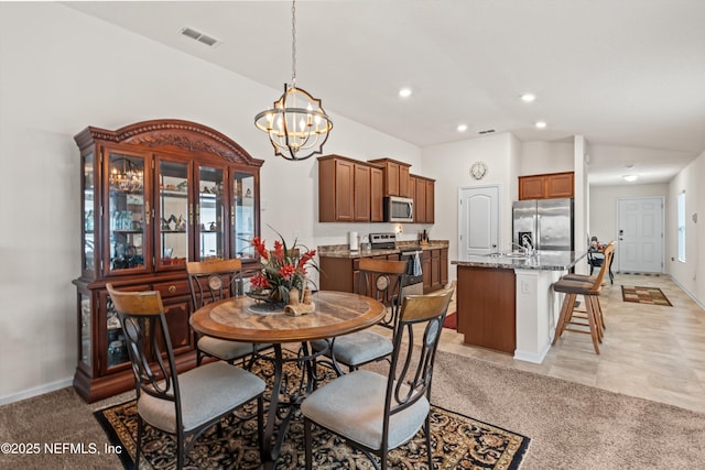 carpeted dining room with lofted ceiling, a notable chandelier, and sink