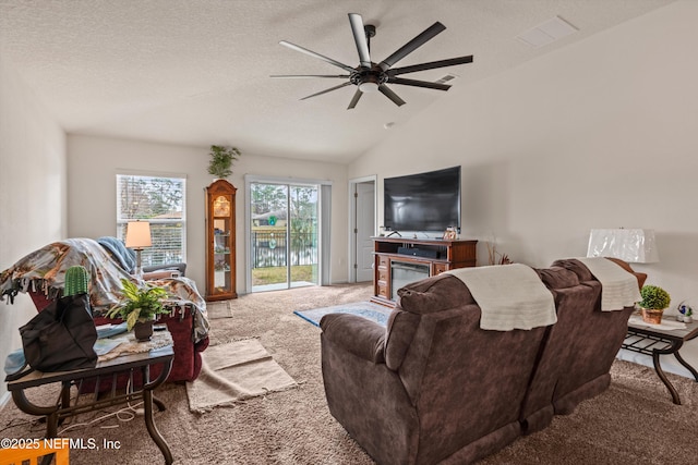 living room featuring ceiling fan, carpet floors, a textured ceiling, and vaulted ceiling