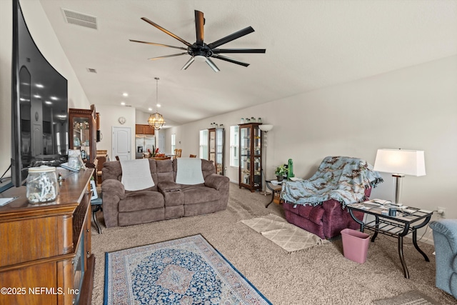 carpeted living room featuring lofted ceiling and ceiling fan with notable chandelier