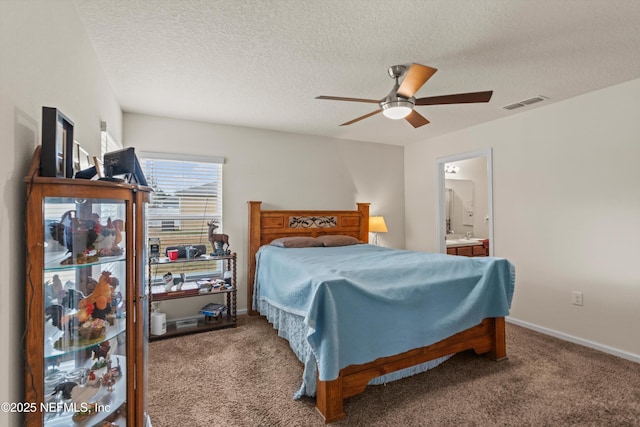 carpeted bedroom with ceiling fan, ensuite bathroom, and a textured ceiling