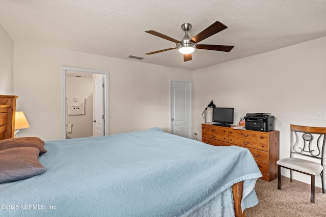 carpeted bedroom with ceiling fan, connected bathroom, and a textured ceiling