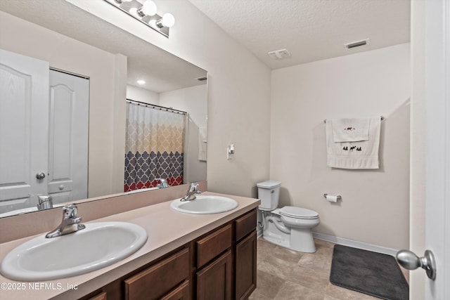 bathroom featuring vanity, curtained shower, a textured ceiling, and toilet