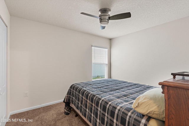 carpeted bedroom with ceiling fan and a textured ceiling