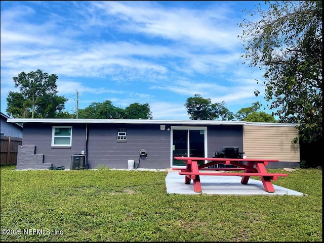 back of house with central AC unit, a patio, and a lawn