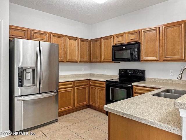 kitchen with sink, light tile patterned floors, black appliances, light stone countertops, and a textured ceiling