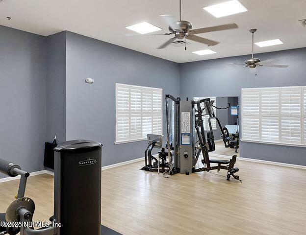 exercise room with light hardwood / wood-style flooring and ceiling fan