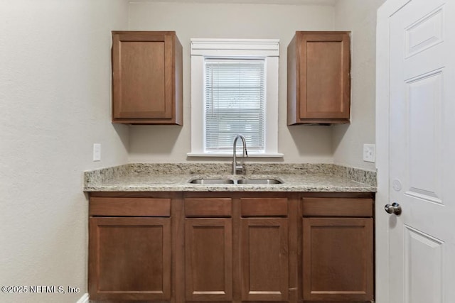 kitchen with light stone counters and sink