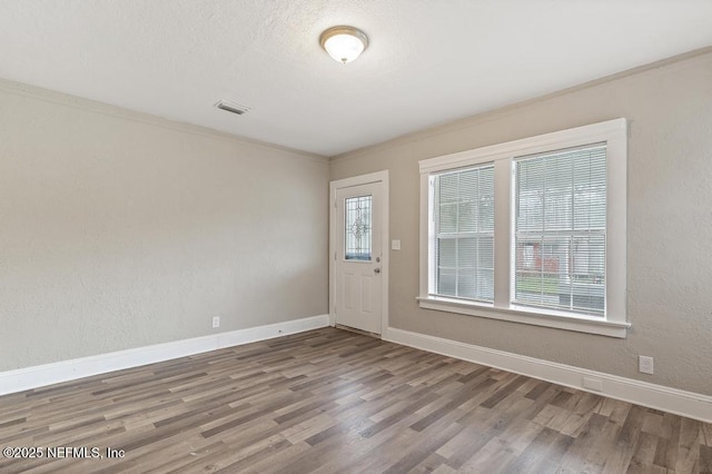 spare room with crown molding and hardwood / wood-style floors