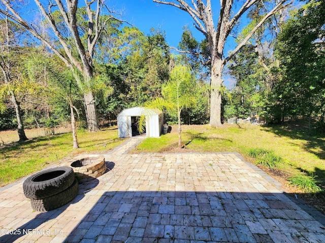 view of patio / terrace with a storage shed and an outdoor fire pit