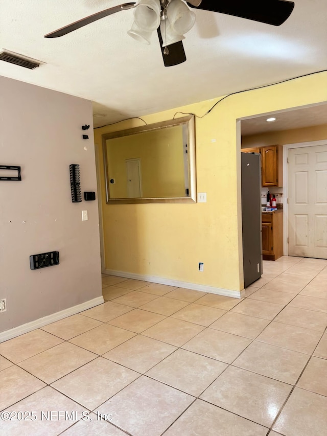 spare room featuring light tile patterned flooring and ceiling fan