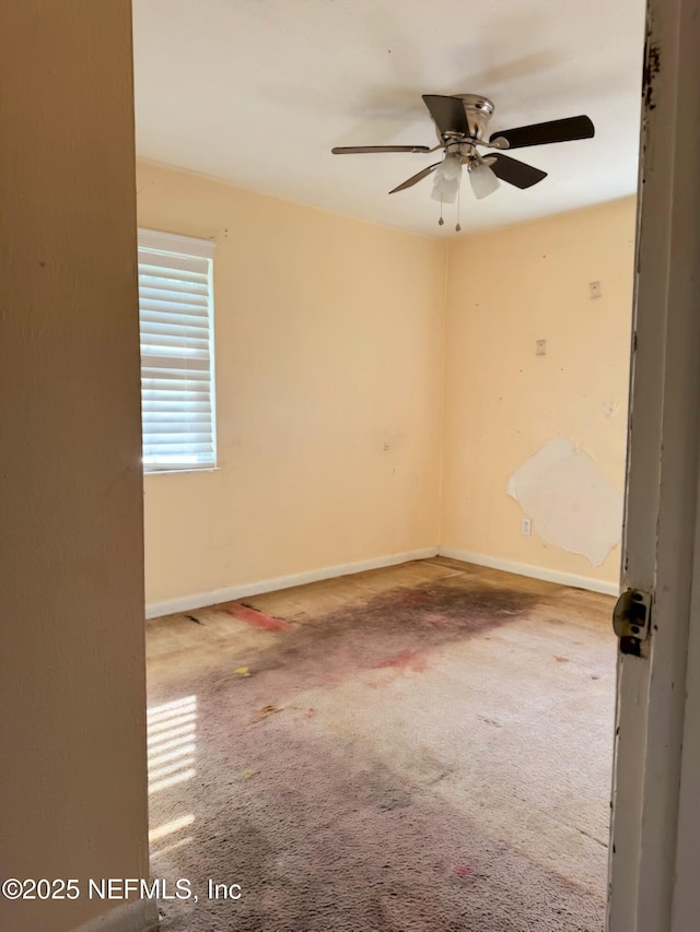 carpeted empty room featuring ceiling fan