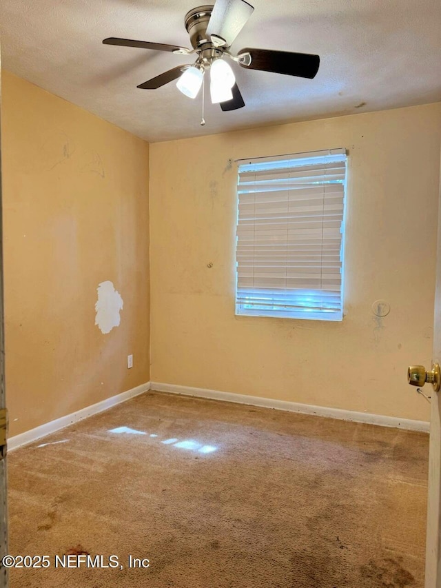 carpeted spare room with ceiling fan and a textured ceiling