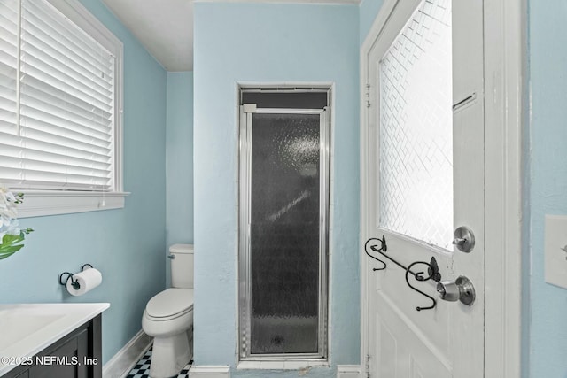 bathroom featuring vanity, toilet, and an enclosed shower