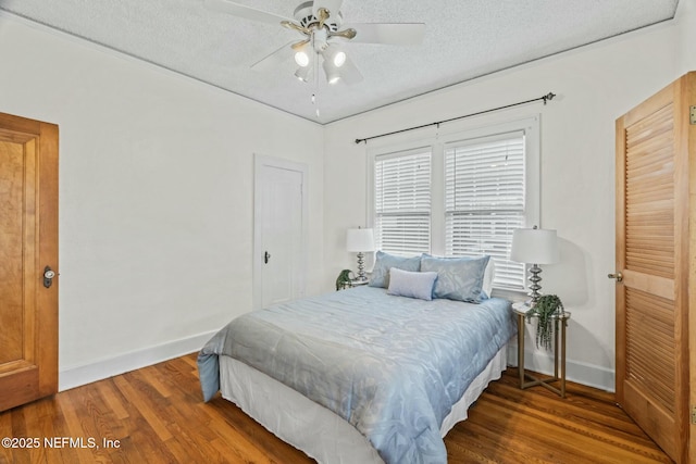 bedroom with hardwood / wood-style floors, a textured ceiling, and ceiling fan