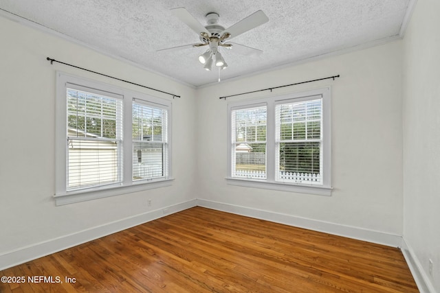 empty room featuring crown molding, ceiling fan, wood-type flooring, and a textured ceiling